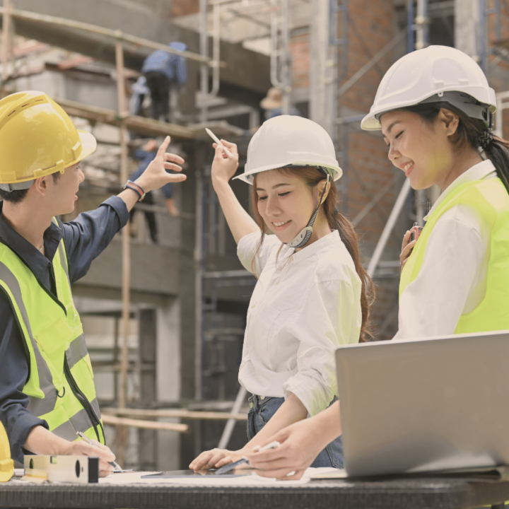 Deux femmes et un homme discutent d'un projet de construction.