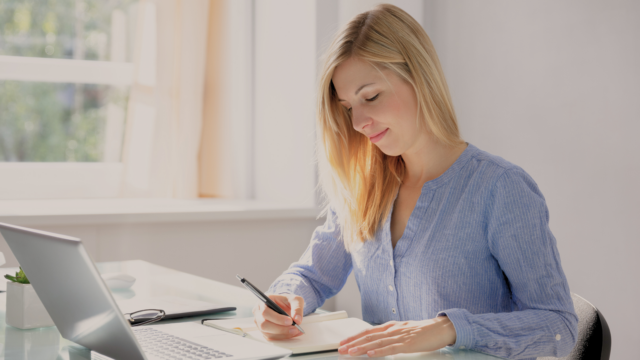 Une femme écrit dans son carnet.