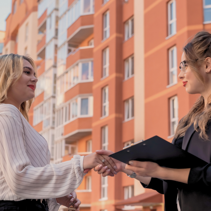 Deux agents immobiliers se serrent la main.