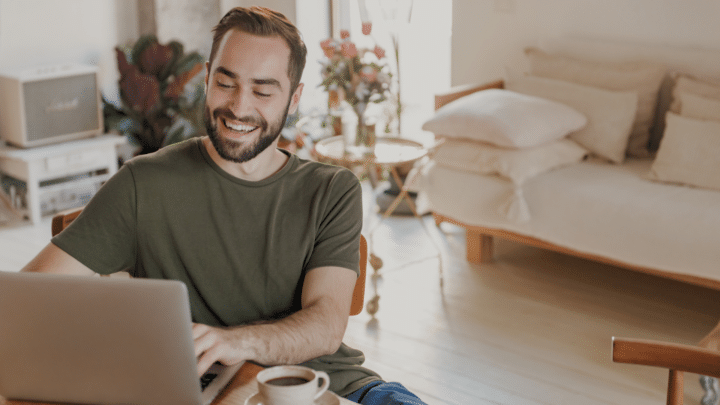 Un homme travaille sur son ordinateur chez lui.