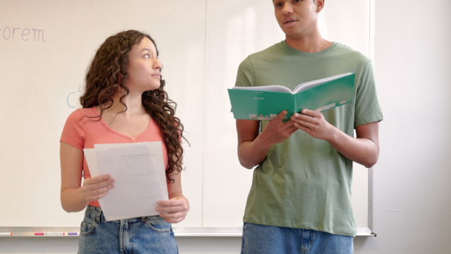 Deux élèves passent un oral devant leur classe.