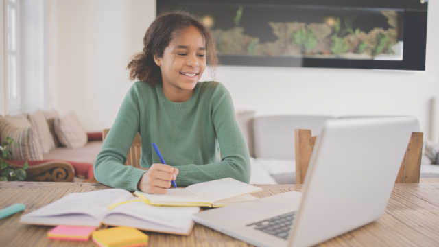Une élève fait ses devoirs et s'exerce sur son ordinateur.