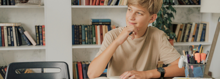 Un adolescent réfléchit en faisant ses devoirs.