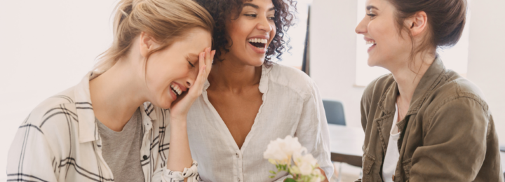 Trois femmes rient aux éclats.