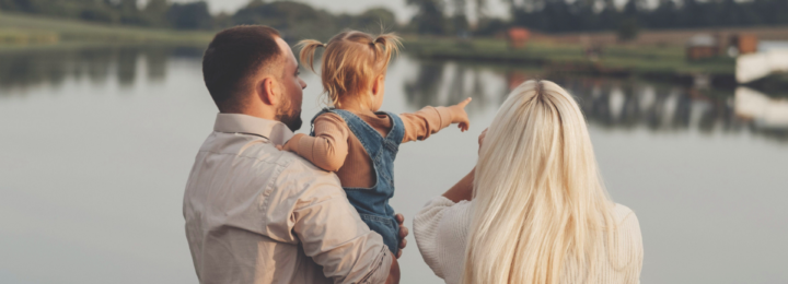 Une famille contemple le paysage au bord d’un lac.