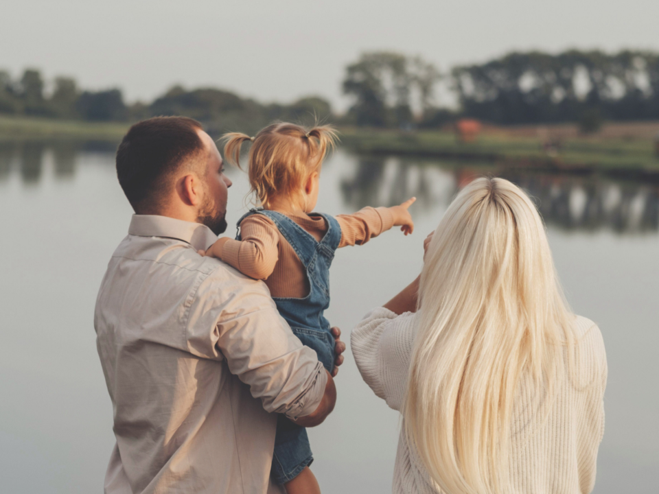 Une famille contemple le paysage au bord d’un lac.