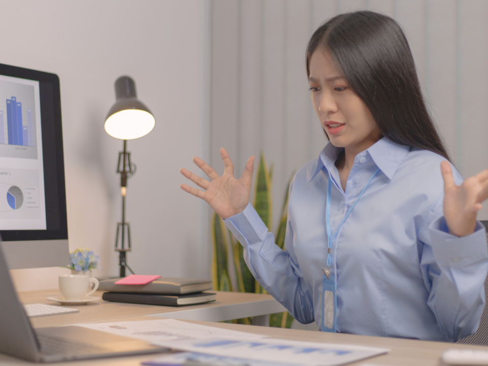 Une employée est surprise face à son ordinateur.