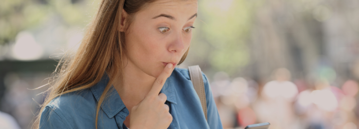 Une jeune fille est surprise en utilisant son téléphone.