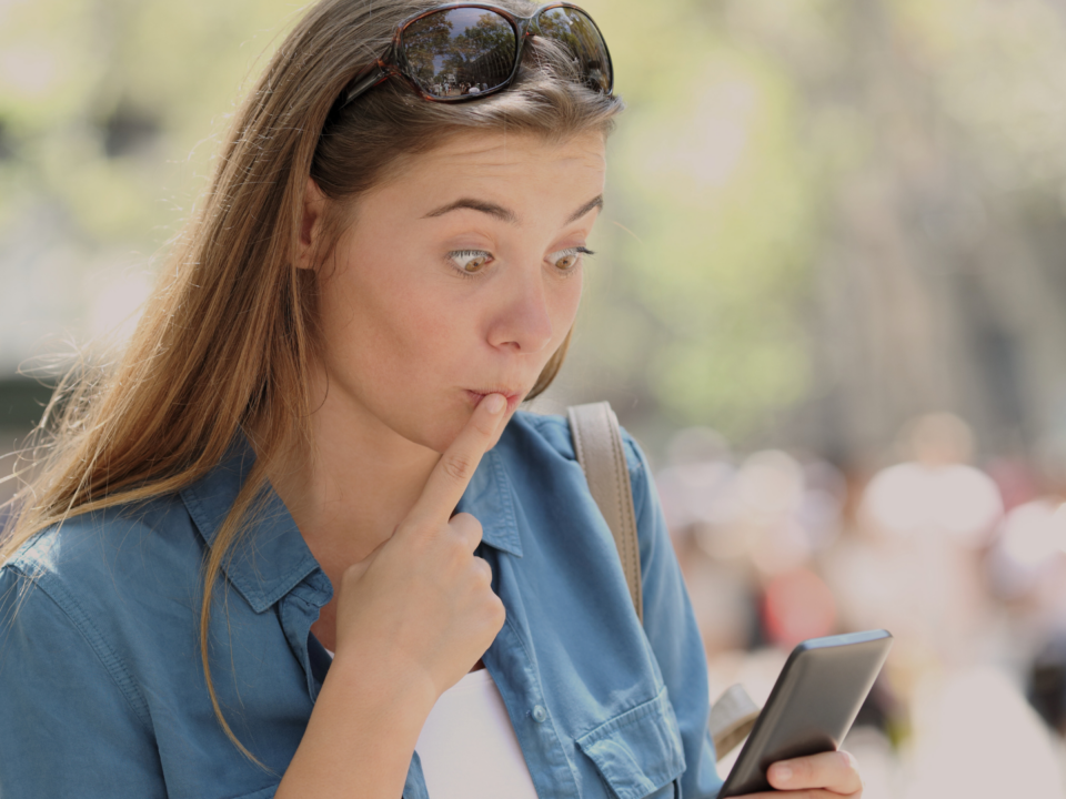 Une jeune fille est surprise en utilisant son téléphone.