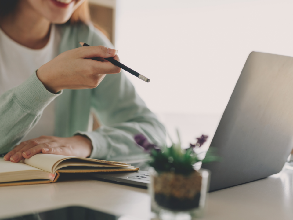 Une jeune femme étudie face à son ordinateur portable.