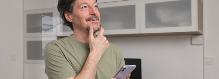 Un homme réfléchit sur son téléphone portable.