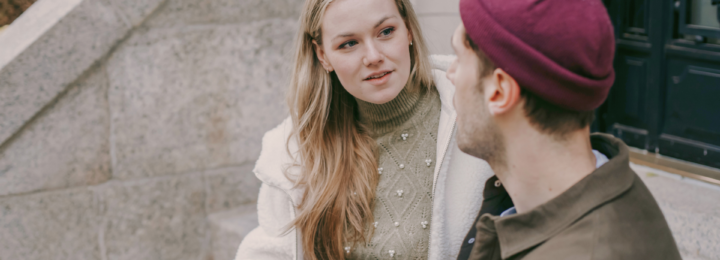 Un couple discute assis sur des marches.