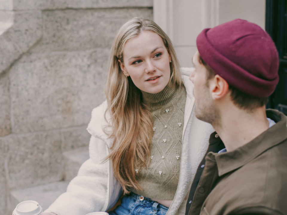 Un couple discute assis sur des marches.