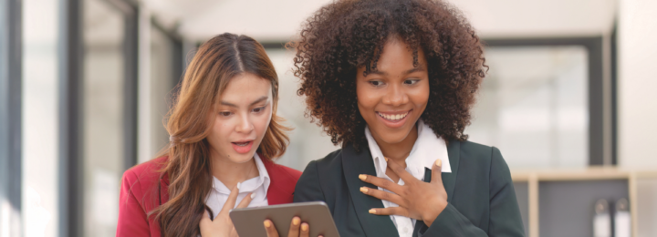 Deux collègues sont surprises en lisant sur leur tablette.