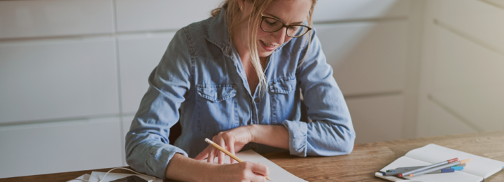 Une femme s'applique pour écrire.