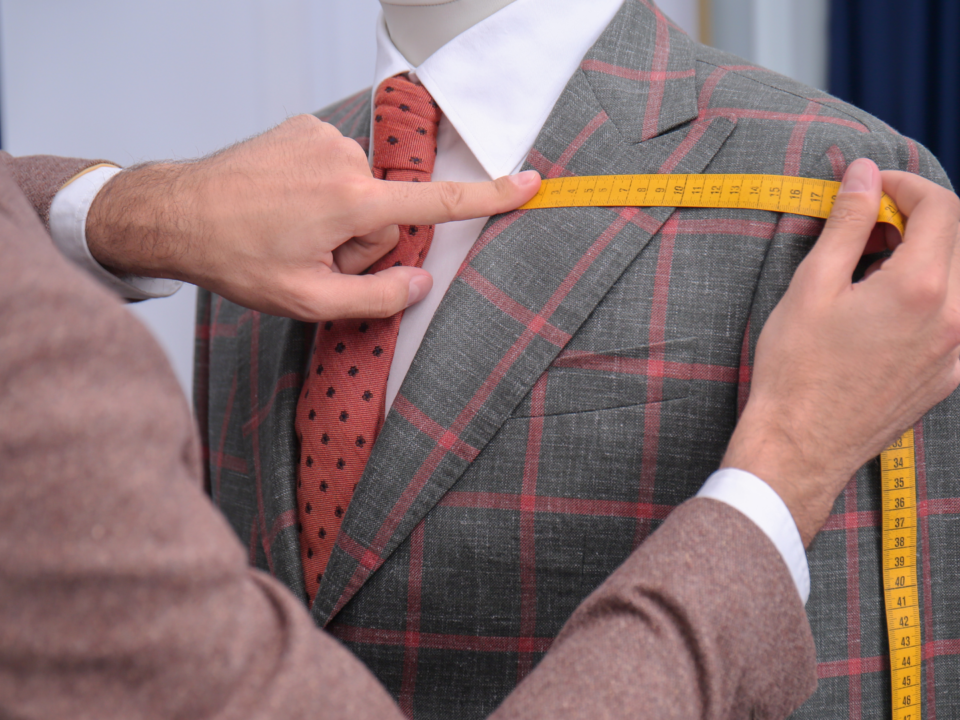 Un homme mesure un costume.