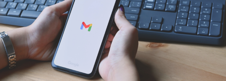 Une femme tient son téléphone portable dans ses mains. Il est en train d'ouvrir l'application Gmail.