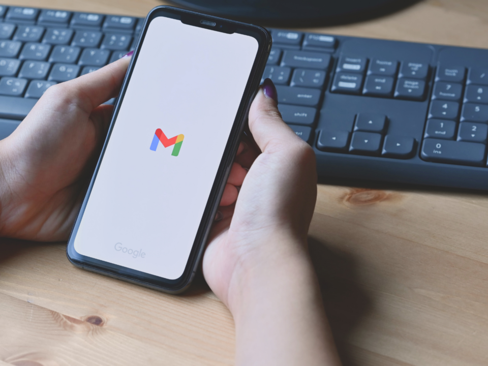 Une femme tient son téléphone portable dans ses mains. Il est en train d'ouvrir l'application Gmail.