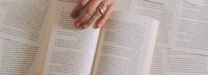 Une main féminine tourne les pages d'un livre.
