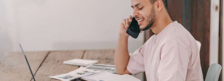 Un homme sourit au téléphone.