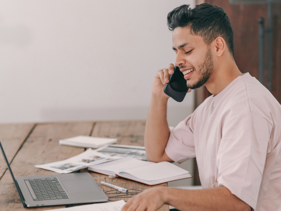 Un homme sourit au téléphone.
