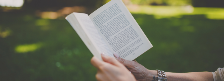 Des mains féminines tiennent un livre.