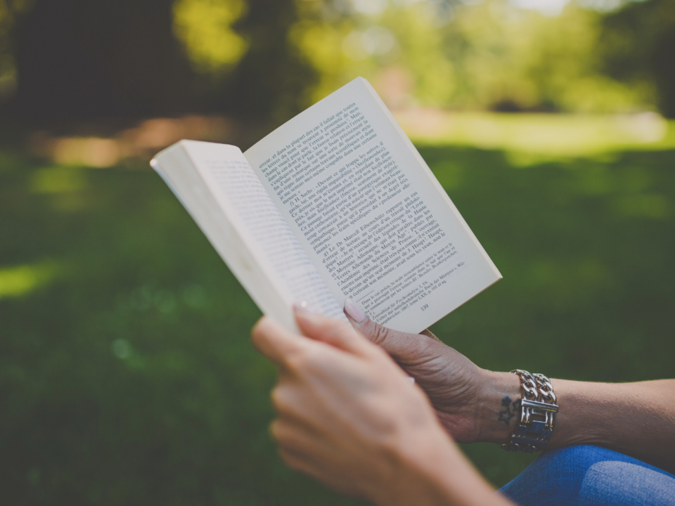 Des mains féminines tiennent un livre.