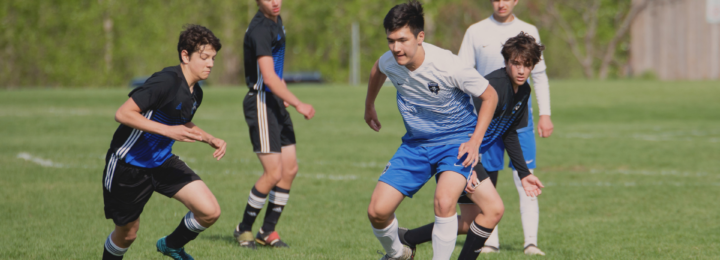 Cinq joueurs de football jouent un match.