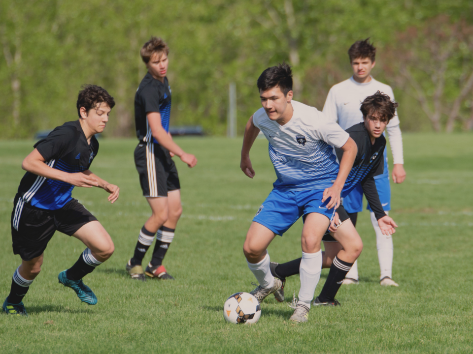 Cinq joueurs de football jouent un match.