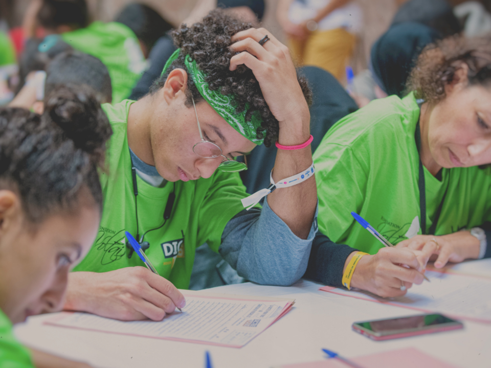Plusieurs personnes font une dictée avec concentration.