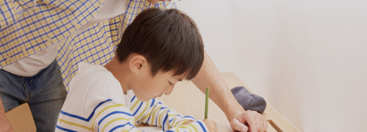 Un père aide son fils à faire ses devoirs.