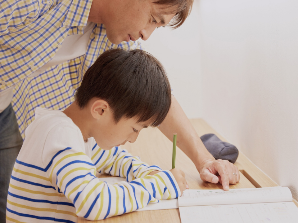 Un père aide son fils à faire ses devoirs.