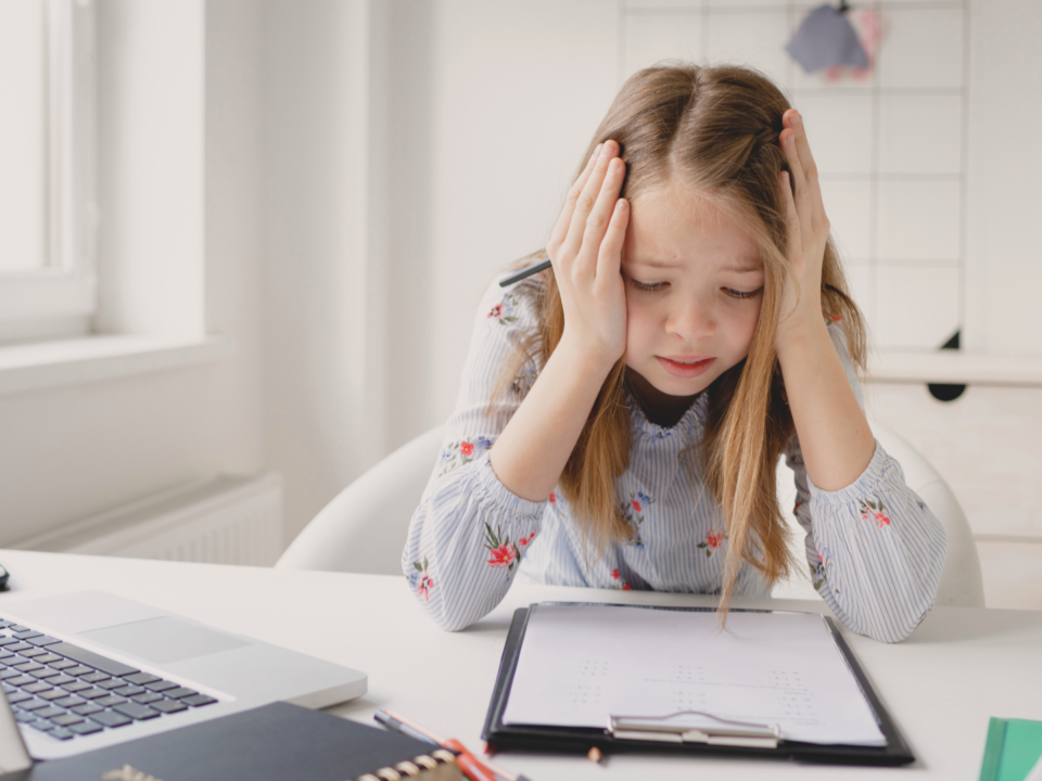 Une enfant est frustrée devant ses devoirs.