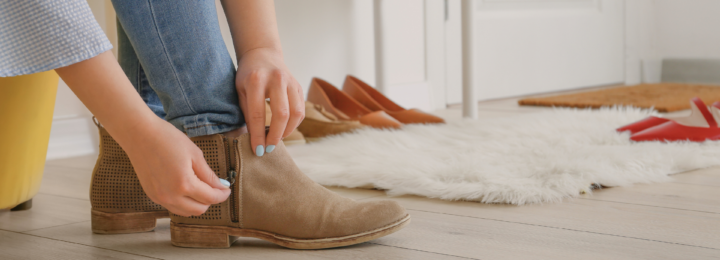 Une femme met ses bottines et ferme un zip.