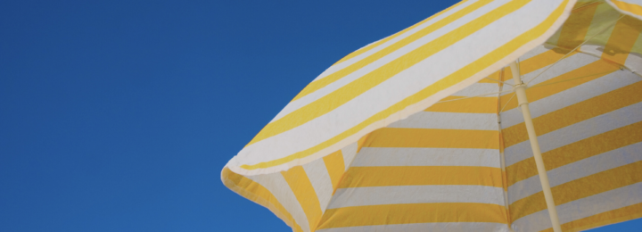 Un parasol jaune et blanc est ouvert.