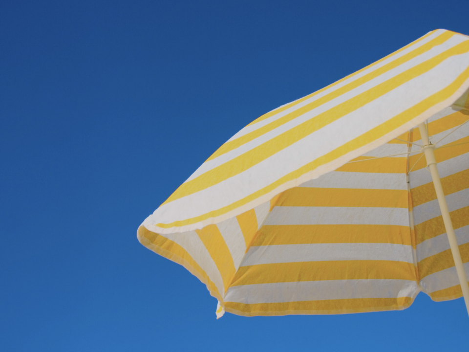 Un parasol jaune et blanc est ouvert.