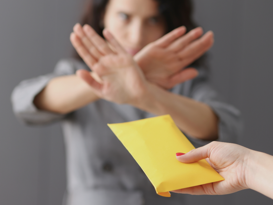 Une femme refuse une enveloppe.