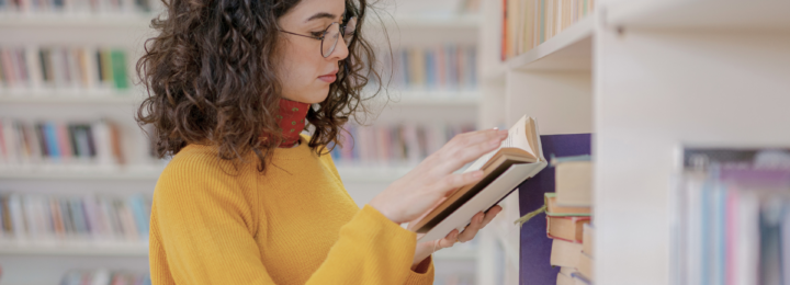 Une femme lit dans une bibliothèque.