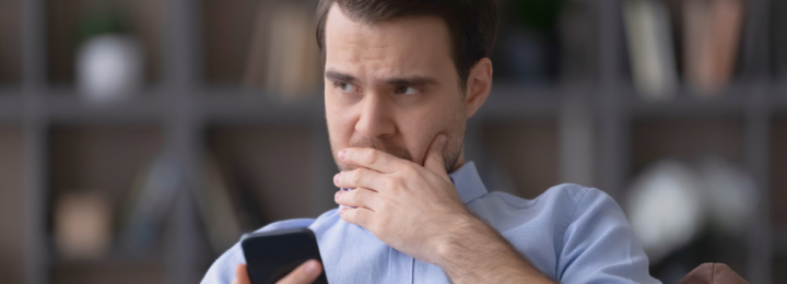 Un homme sur son téléphone portable réfléchit.