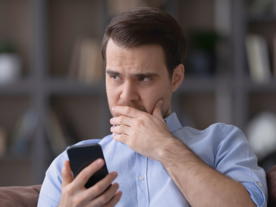 Un homme sur son téléphone portable réfléchit.
