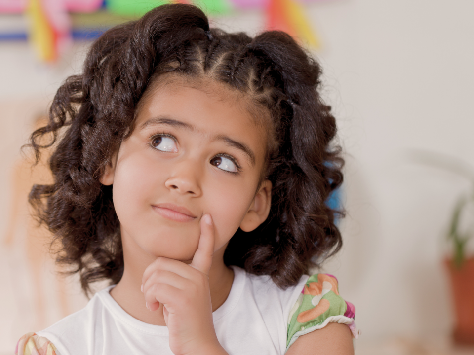 Une petite fille réfléchit de manière malicieuse.