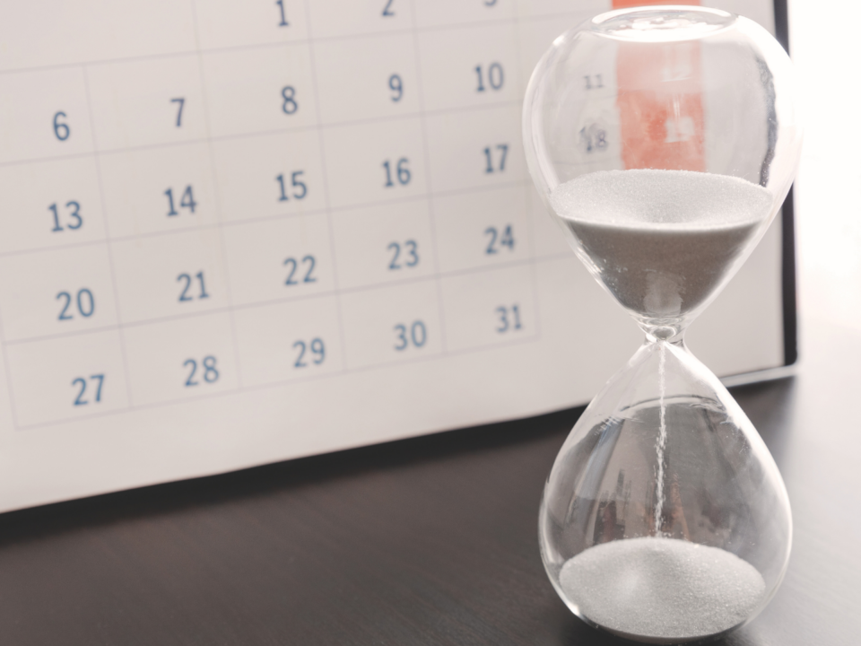 Un sablier s'écoule devant un calendrier.
