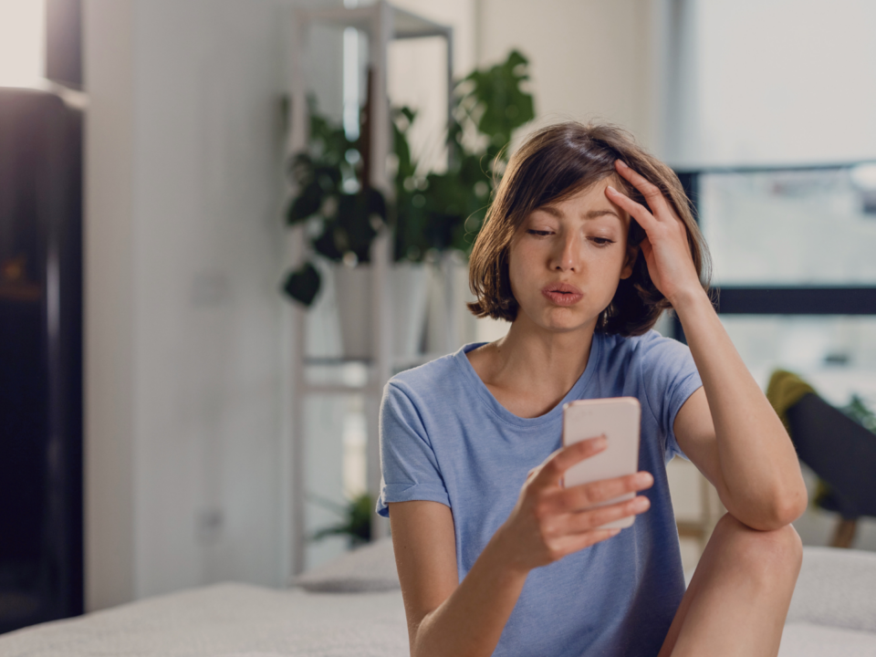Une femme hésite à écrire un message.