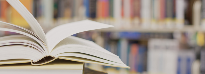 Un dictionnaire est ouvert sur un bureau de bibliothèque.