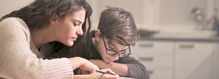 Une mère aide son enfant à faire ses devoirs.