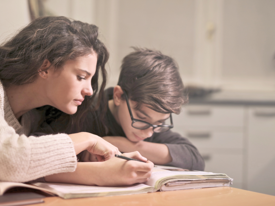 Une mère aide son enfant à faire ses devoirs.