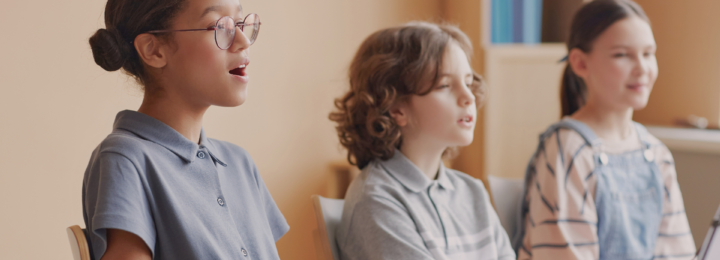 Trois enfants s'entraînent au chant.