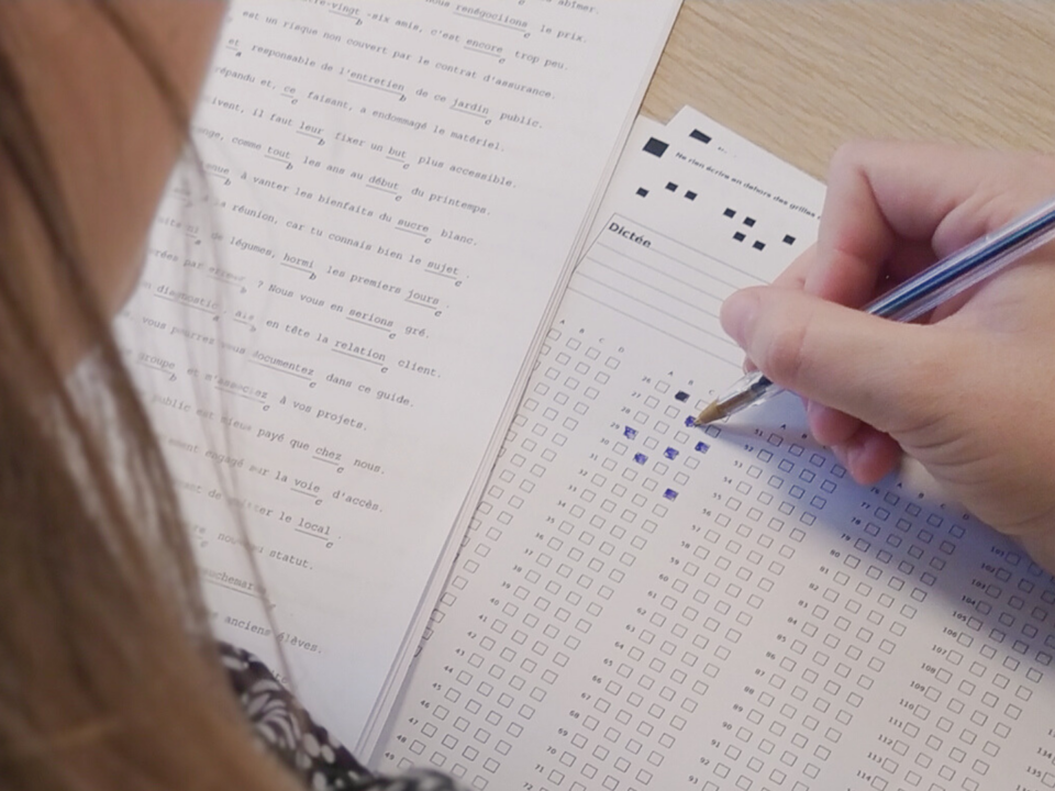 Une jeune fille passe le Certificat Voltaire.
