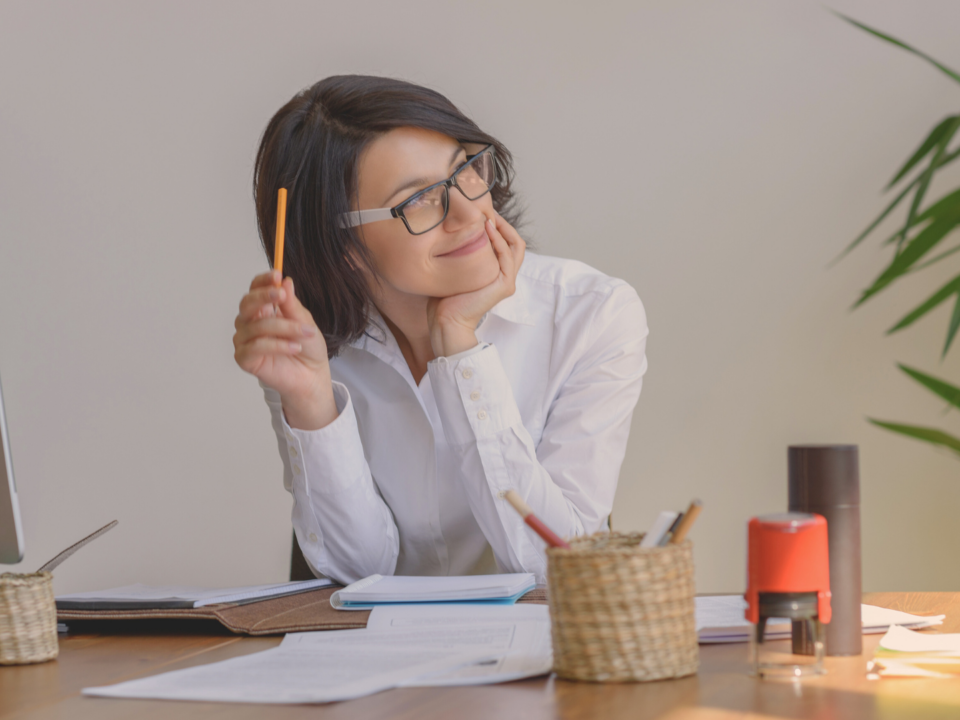 Une femme réfléchit à son bureau.
