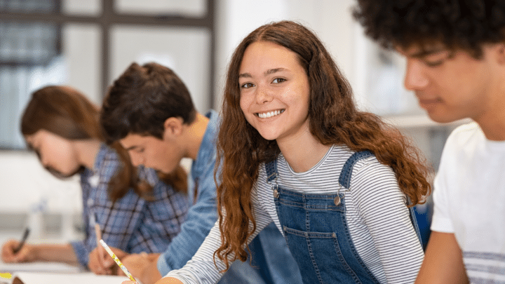 Une élève souriante pendant un cours en classe.